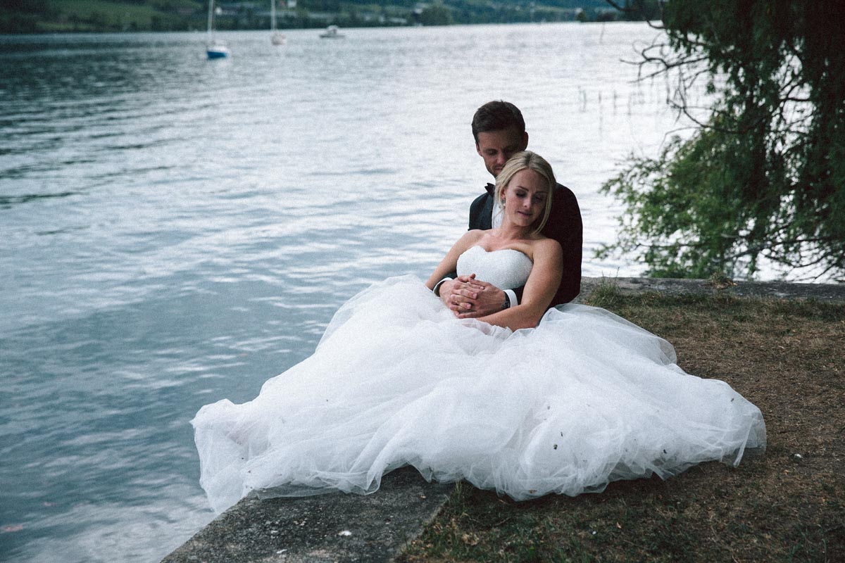 Verliebtes Brautpaar sitzend am See, Deutschland