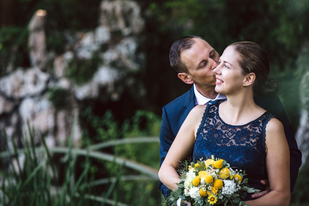 Bräutigam küsst Braut, Brautstrauss, gelbe und weisse Blumen